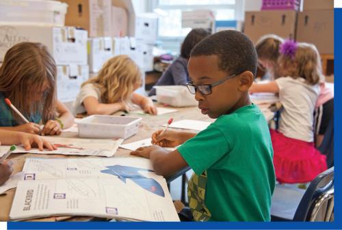 Boy Drawing in Classroom with Classmates